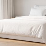 Chambre lumineuse avec un matelas blanc et des draps clairs, symbole de propreté et de fraîcheur