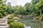 Chemin de pas japonais menant à un bassin avec lanternes en pierre