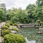 Chemin de pas japonais menant à un bassin avec lanternes en pierre