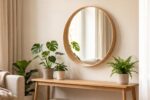 Miroir scandinave rond en bois clair au-dessus d'une console en bois, reflétant une lumière douce dans un salon hygge