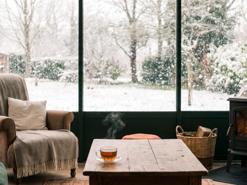Intérieur douillet d'une véranda parfaitement étanche, face à un paysage enneigé en hiver