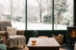Intérieur douillet d'une véranda parfaitement étanche, face à un paysage enneigé en hiver