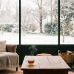 Intérieur douillet d'une véranda parfaitement étanche, face à un paysage enneigé en hiver
