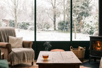 Intérieur douillet d'une véranda parfaitement étanche, face à un paysage enneigé en hiver