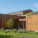 Maison écologique moderne combinant bois, paille et terre crue pour une isolation et une performance thermique optimales