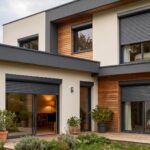 Façade moderne d'une maison résidentielle avec volets roulants alu ou PVC fermés et ouverts, sous un ciel nuageux.
