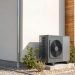 Installation d'une pompe à chaleur air-eau moderne et discrète sur la façade d'une maison contemporaine